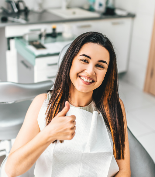 Smiling dental patient giving a thumbs up after a positive dental appointment